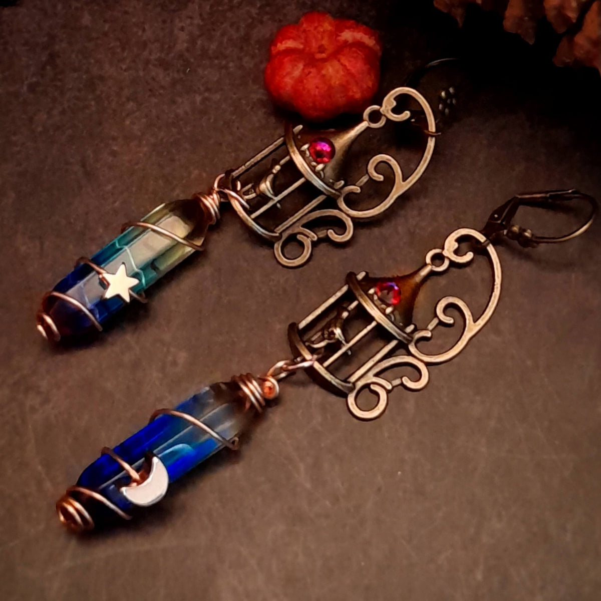 gold moon and star bird cage earrings with blue and purple color changing drop crystals