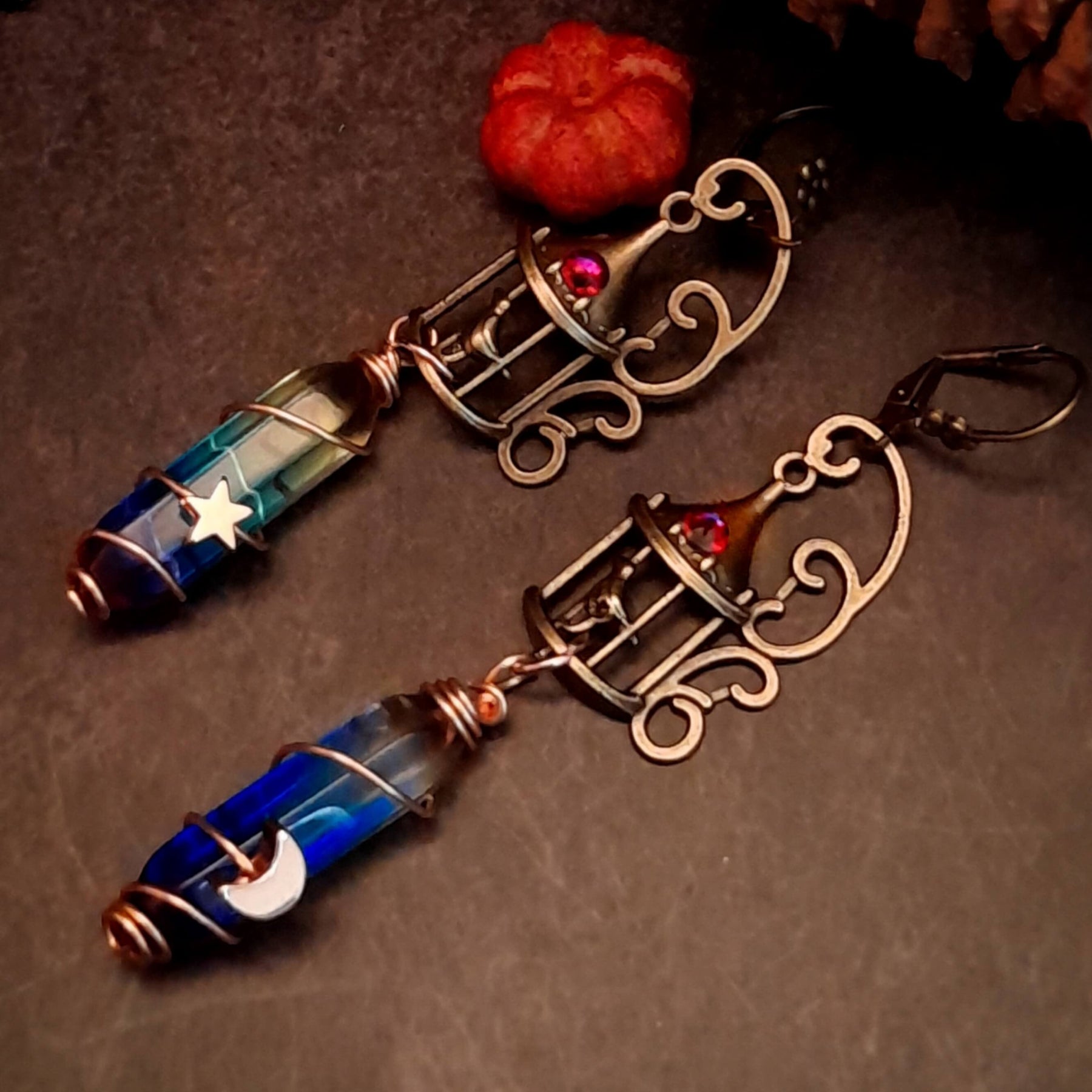 gold moon and star bird cage earrings with blue and purple color changing drop crystals
