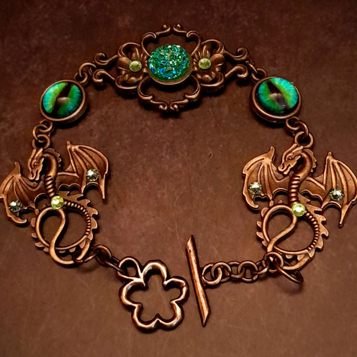 green druzy crystal bracelet with green dragon eyes and brass dragons swarovski green crystals and flower clasp