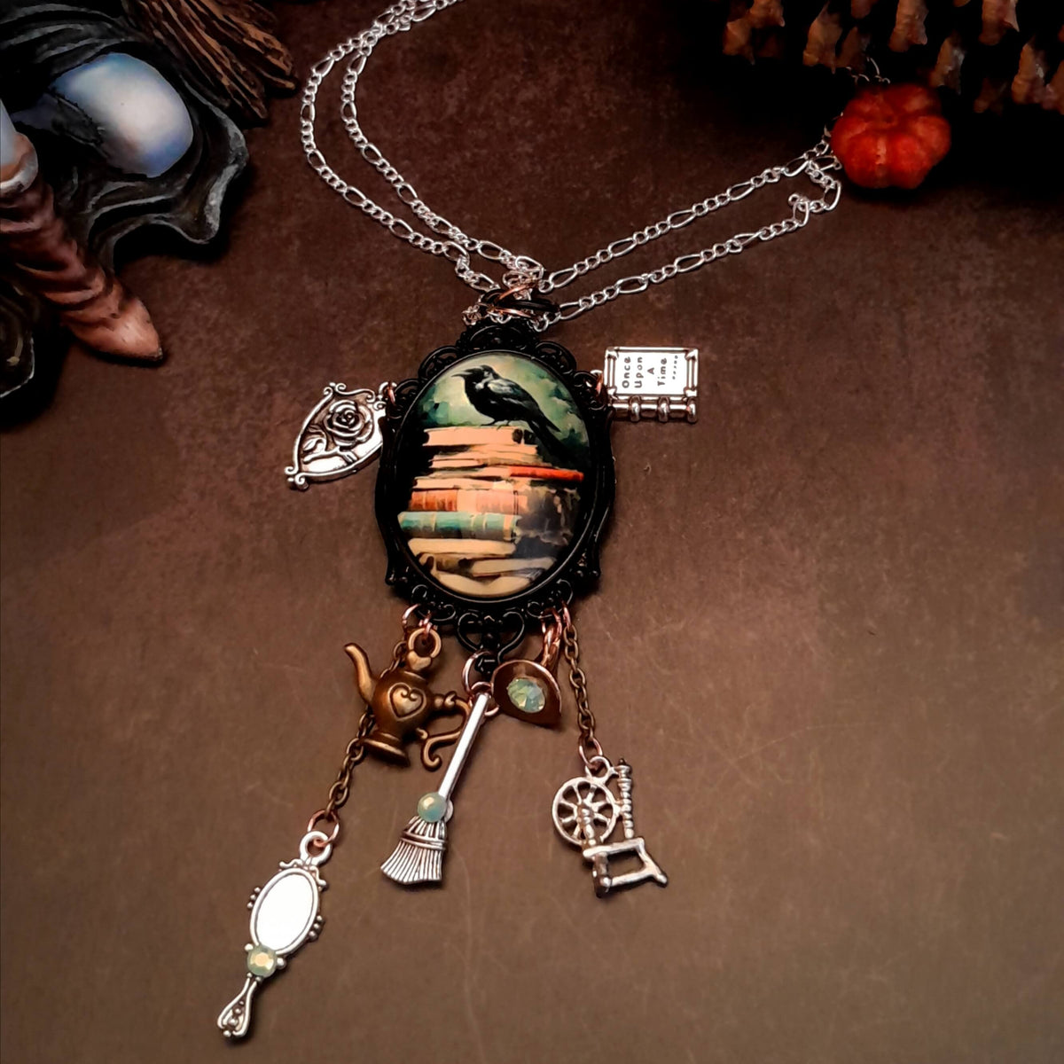 fairytale necklace with book mirror spinning wheel crest magic lamp witch hat broom and crow on books