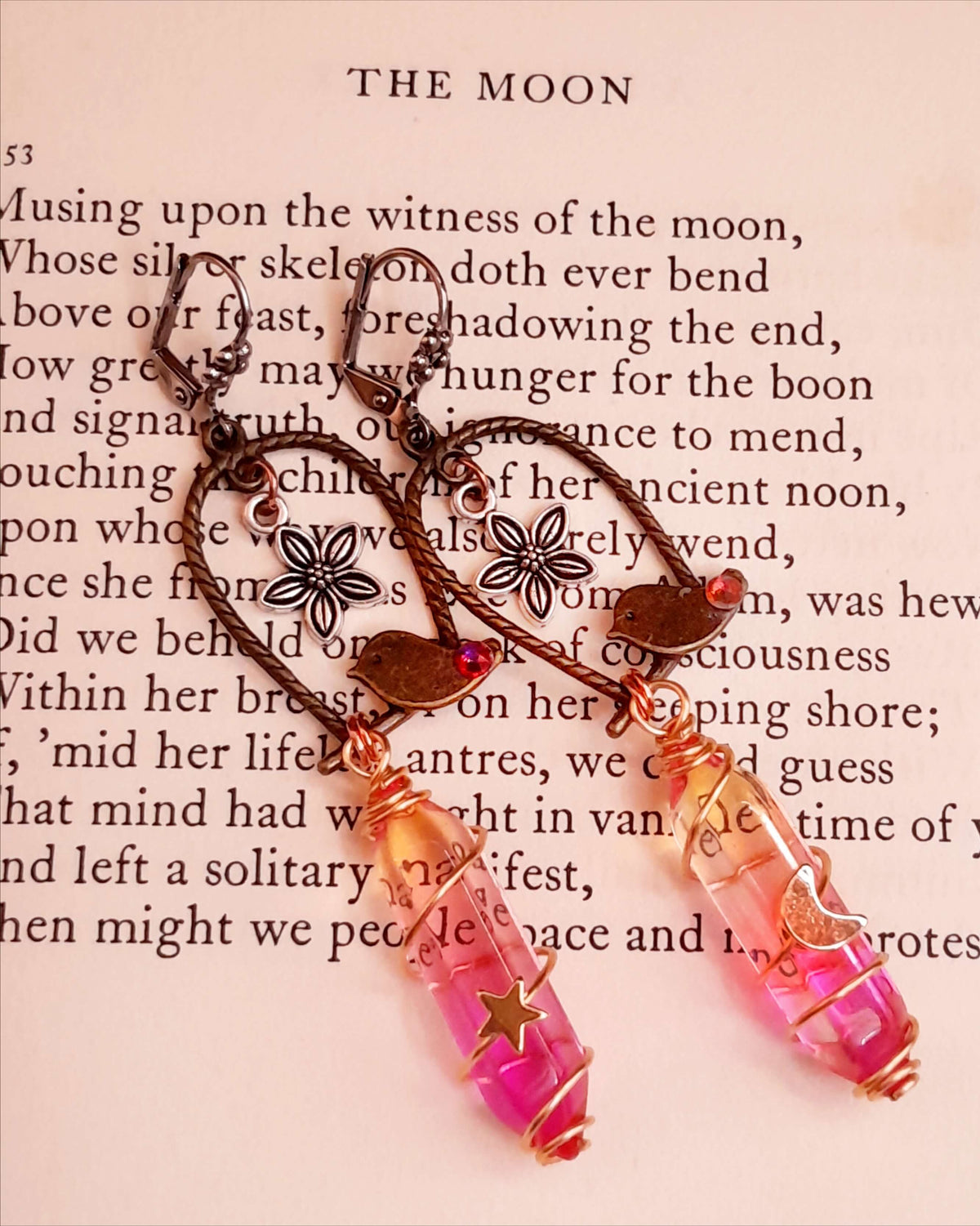 bird earrings with dangling flower and glass drops that change color from yellow to pink. wire wrapped with a moon and star