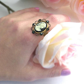 black lady victorian cameo ring on hand with white rose