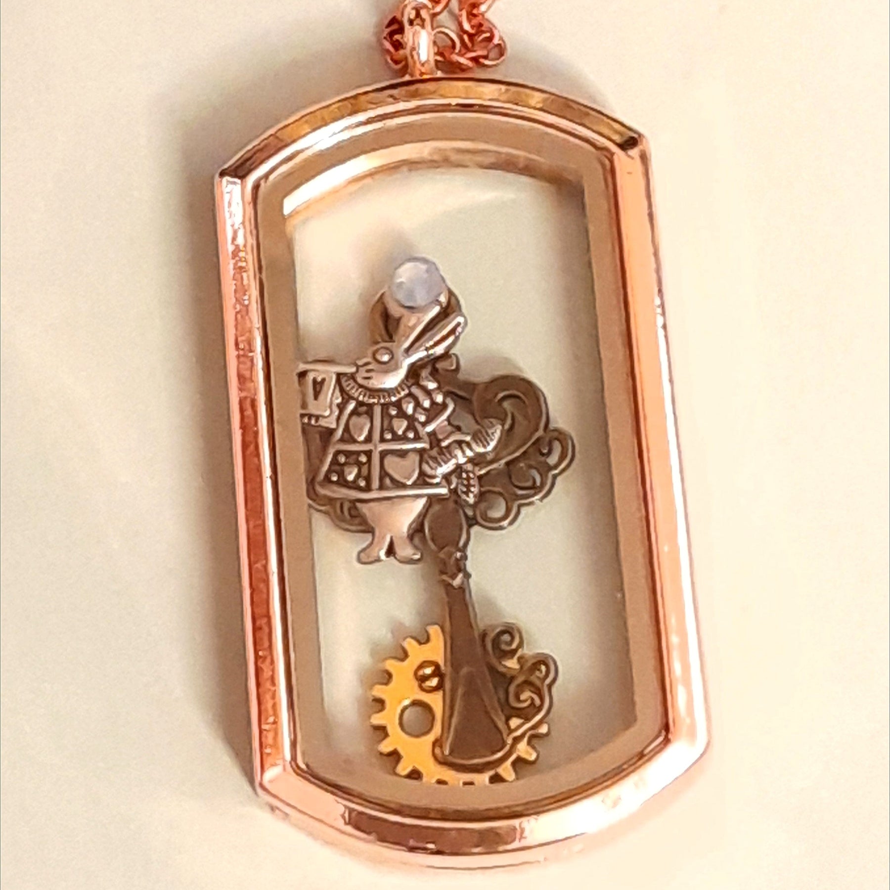 Handmade magical fantasy Alice in Wonderland openable rectangle locket necklace in rose gold tone with White Rabbit charm, gear, clock face, teacup and watch hand charms, Victorian style vintage style