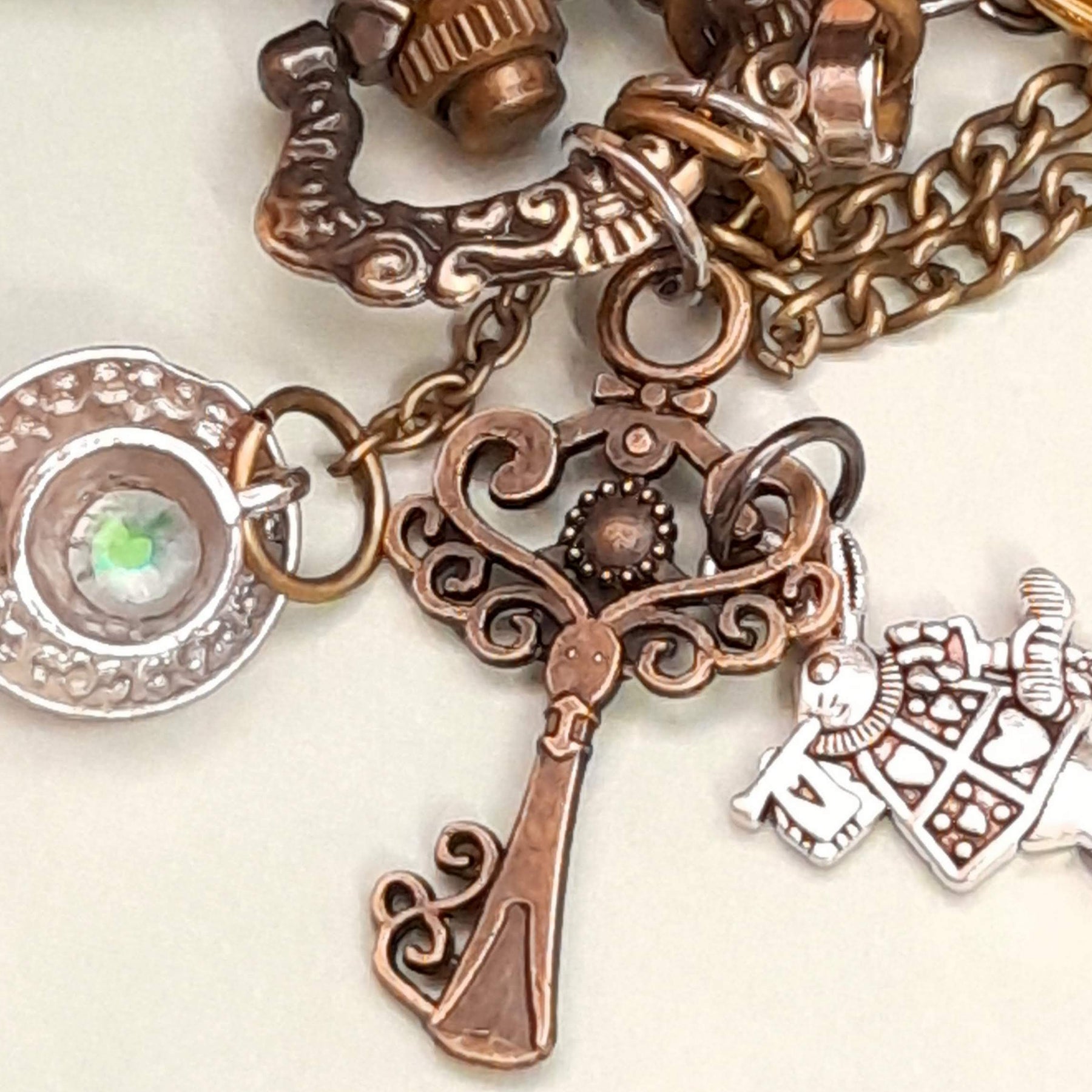 Alice in Wonderland pocket watch necklace charm detail showing ornate key teacup and White Rabbit charms with multicolor Swarovski crystals antiqued brass Victorian style vintage style fantasy handmade swarovski crystals