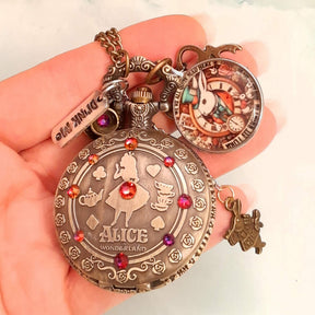 Alice in Wonderland pocket watch necklace held in hand full front view with White Rabbit charm and red Swarovski crystals antiqued brass Victorian style vintage style fantasy handmade