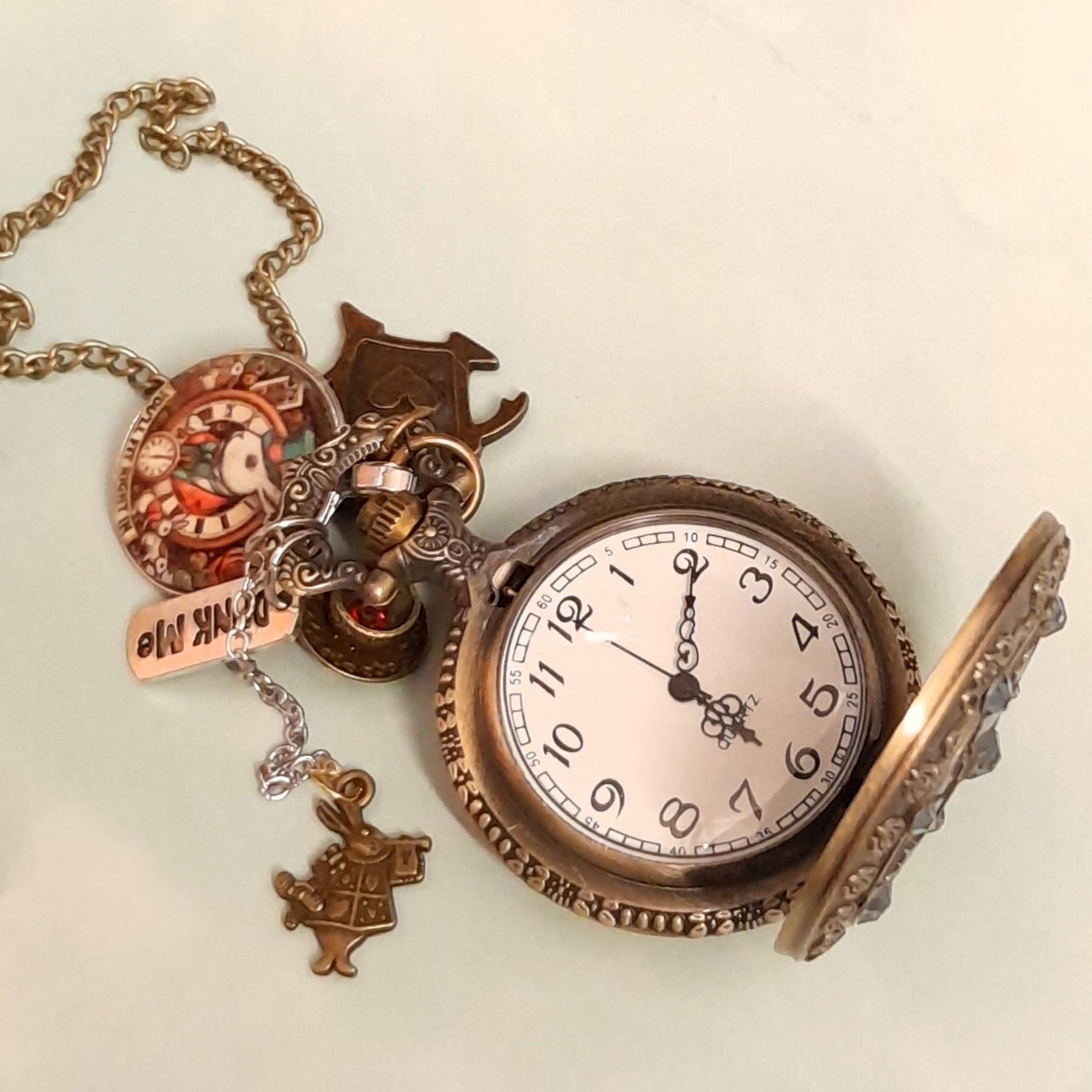 Alice in Wonderland pocket watch necklace open showing clock face with White Rabbit and Drink Me charms antiqued brass Victorian style vintage style fantasy handmade