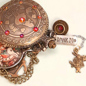 Alice in Wonderland pocket watch necklace side detail showing Drink Me charm teacup and White Rabbit antiqued brass red Swarovski crystals Victorian style vintage style fantasy handmade