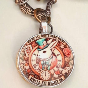 Alice in Wonderland pocket watch necklace detail showing steampunk gear disc and white crystal disc with multicolor Swarovski crystal antiqued brass Victorian style vintage style fantasy handmade