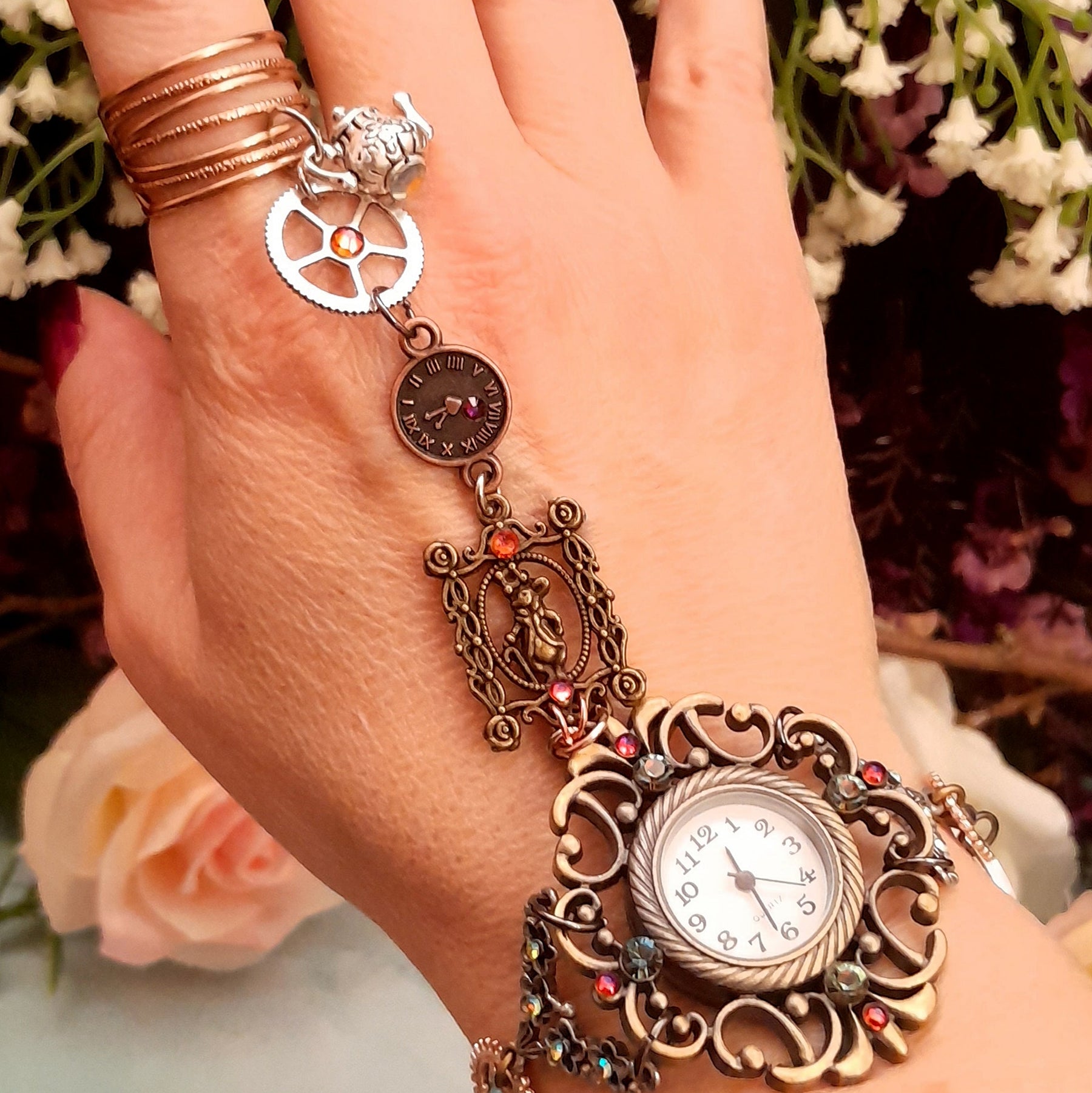 Handmade magical fantasy Alice in Wonderland Victorian style hand chain watch with Swarovski crystals worn on wrist close up of filigree watch face