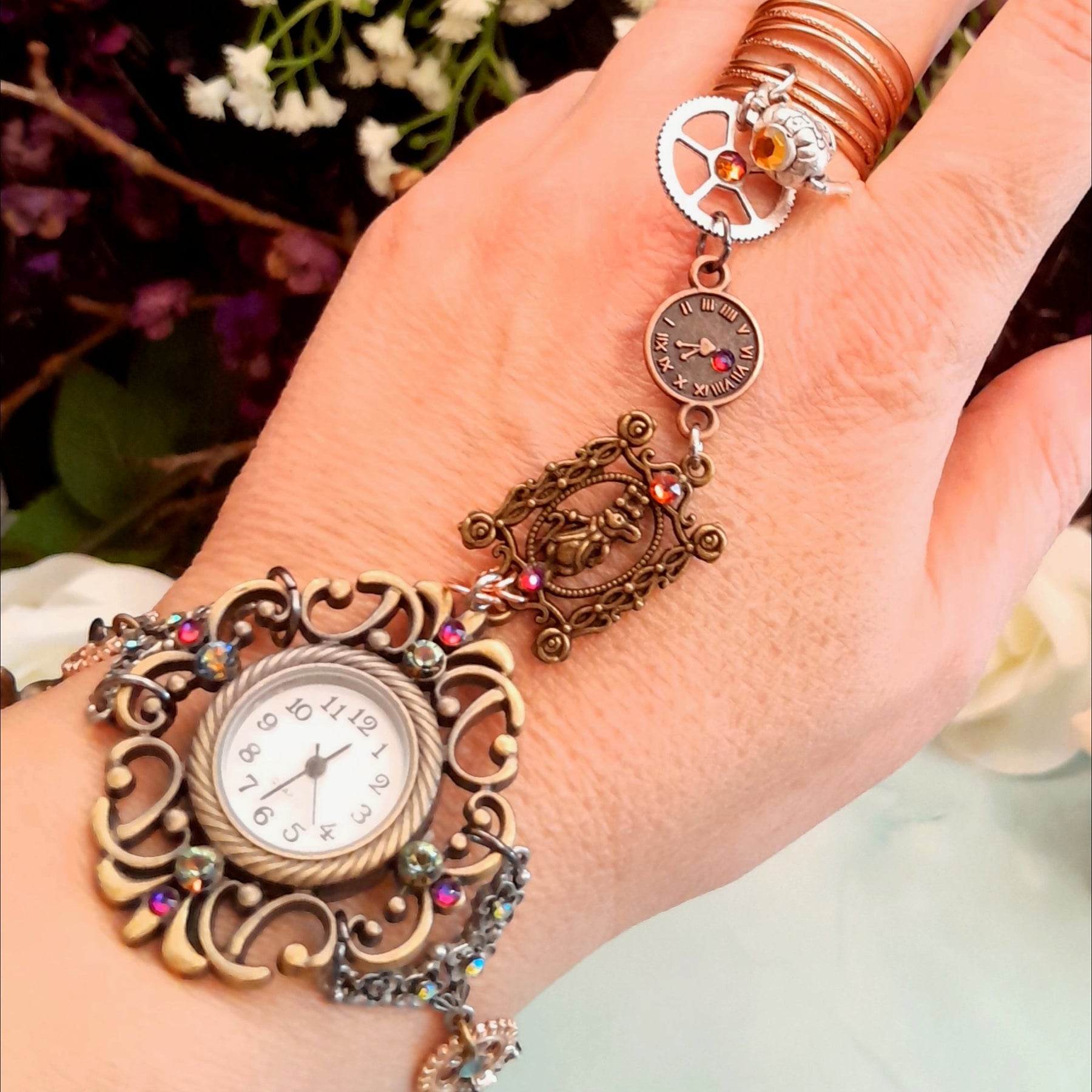 Magical fantasy Alice in Wonderland Victorian style hand chain watch with Swarovski crystals flat lay showing full piece with adjustable ring