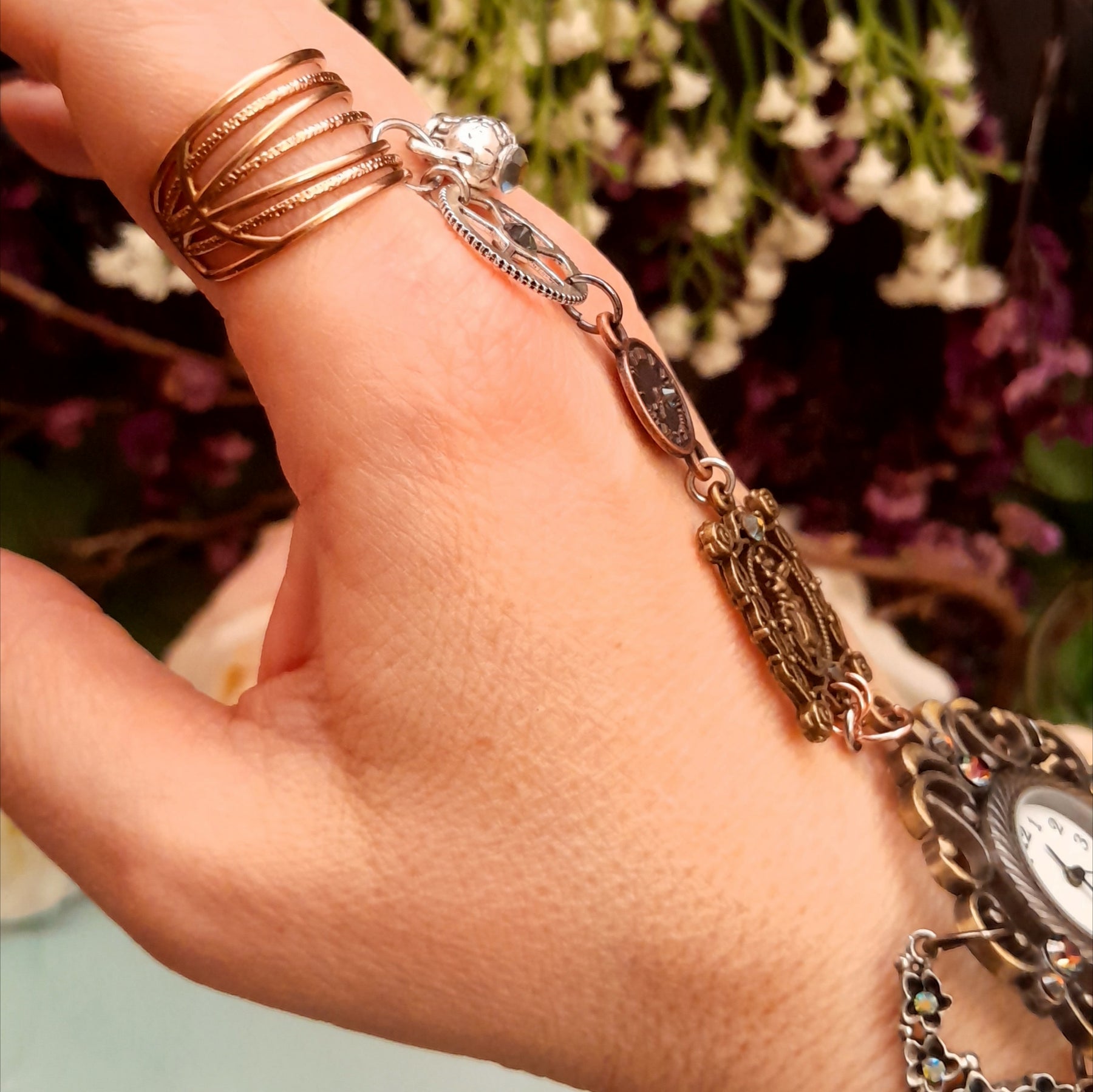 Handmade Alice in Wonderland Victorian style hand chain watch worn on hand back view showing adjustable ring and chain connecting to filigree watch