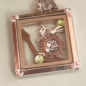 Magical fantasy Alice in Wonderland square locket necklace back view showing  with White Rabbit and gear charms, green Swarovski crystal corner accents,  chain, Victorian style vintage style