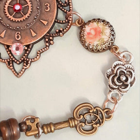 Alice in Wonderland steampunk hand chain slave bracelet closeup of clock charm rose cameo beads ornate keys 3D flower Swarovski crystals Victorian style vintage style handmade Rachel Flam Design