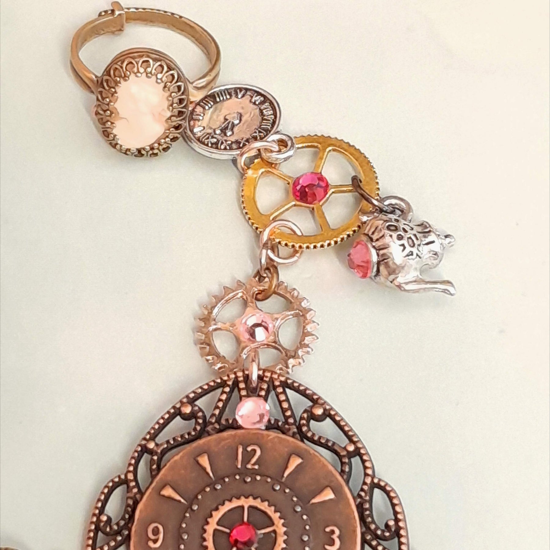 Alice in Wonderland steampunk hand chain slave bracelet closeup of cream cameo ring steampunk gears teapot charm Swarovski rose crystals Victorian style vintage style handmade Rachel Flam Design
