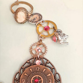 Alice in Wonderland steampunk hand chain slave bracelet closeup of cream cameo ring steampunk gears teapot charm Swarovski rose crystals Victorian style vintage style handmade Rachel Flam Design