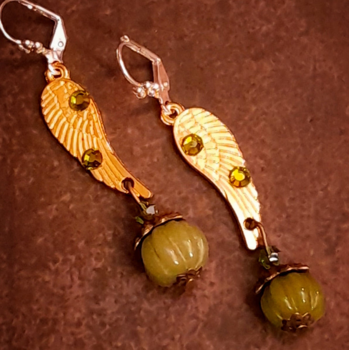 Victorian style vintage style angel wing drop earrings featuring Swarovski Olivine crystals and ribbed pumpkin dangles, close-up product photo by Rachel Flam Design