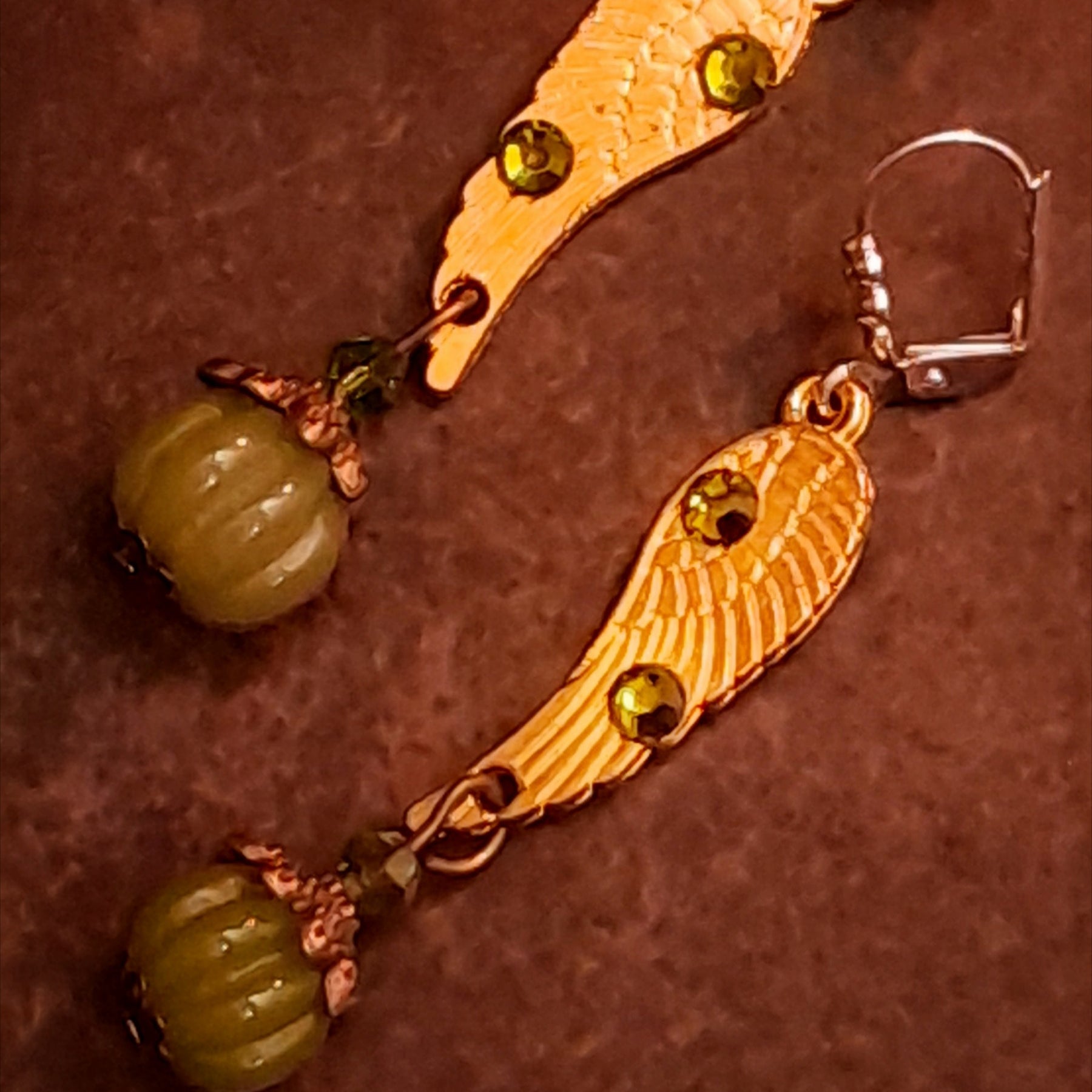 Victorian style vintage style angel wing drop earrings decorated with Swarovski Olivine crystals and finished with ribbed pumpkin dangles, detailed product photo by Rachel Flam Design