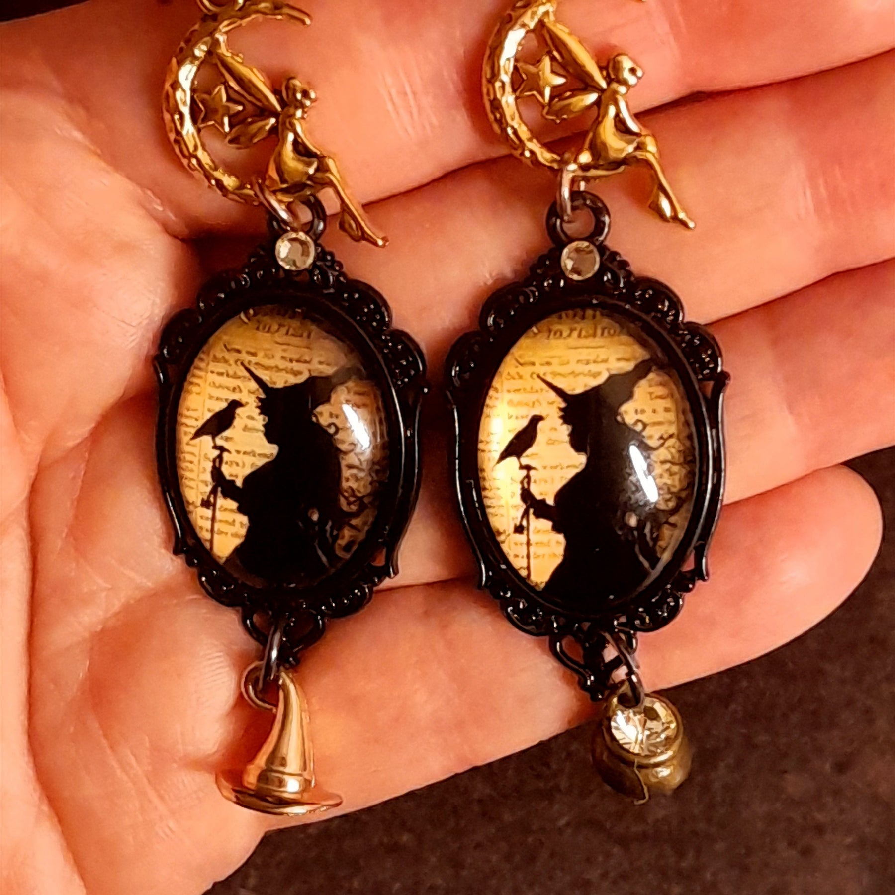 One of a kind Halloween witchy earrings with fairy charms, crescent moons, ravens, a witch hat, and cauldron details arranged in an asymmetrical design, Victorian style vintage style fantasy jewelry
