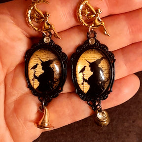 One of a kind Halloween witchy earrings with fairy charms, crescent moons, ravens, a witch hat, and cauldron details arranged in an asymmetrical design, Victorian style vintage style fantasy jewelry
