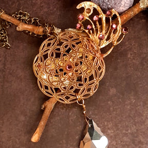 Victorian style vintage style back of masquerade mask necklace pendant showing a filigree flower medallion with a dangling Swarovski crystal drop