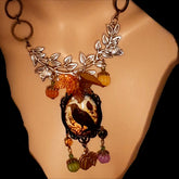 Handmade black crow and pumpkin Halloween necklace with leafy branches, autumn foliage, orange pumpkins, raven focal artwork, and green and purple Swarovski crystals, Victorian style and vintage style magical fantasy jewelry by Rachel Flam Design