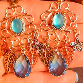 Magical fantasy chandelier earrings in Victorian style and vintage style with turquoise cat eye cabochons, botanical details, flowers, leaves, and blue violet glass drops by Rachel Flam Design

