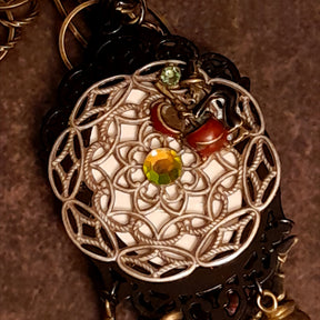Victorian style vintage style dragon and castle fantasy necklace showing its detailed filigree reverse, magical charms, and Swarovski crystals, Rachel Flam Design

