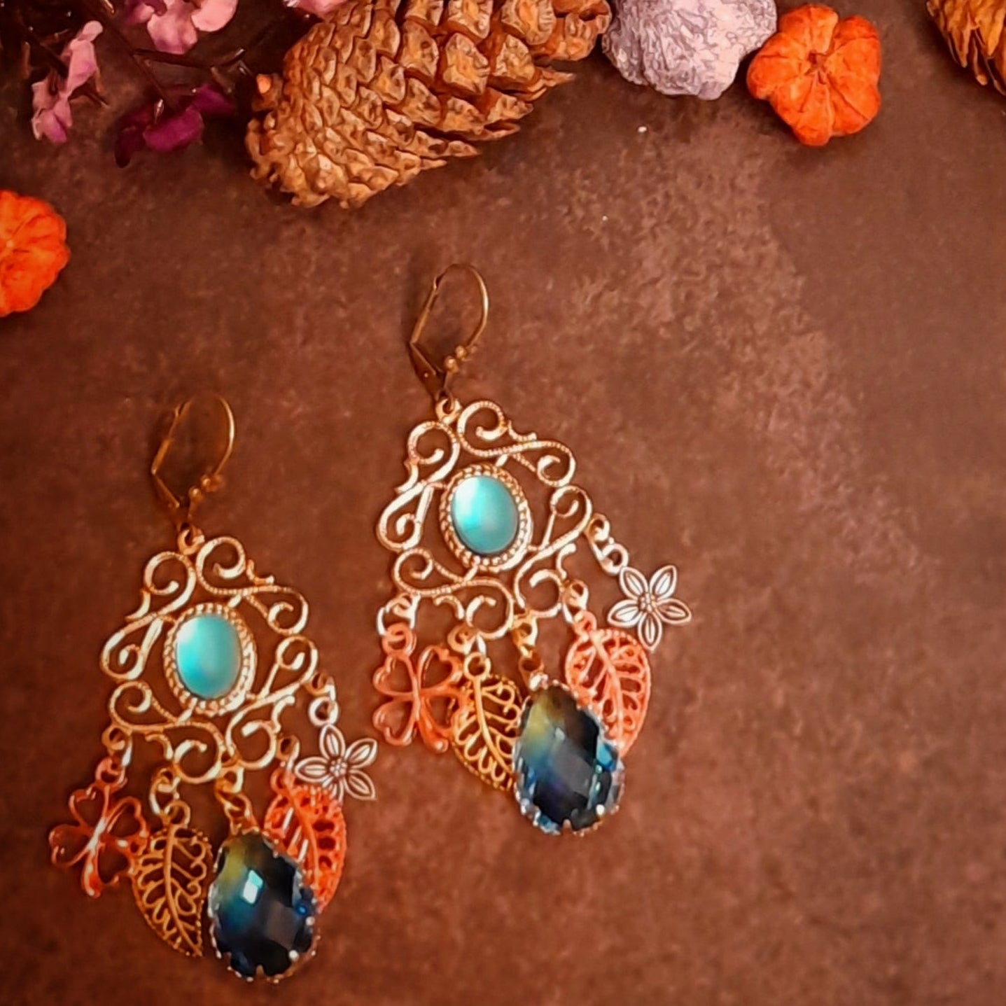 Vintage style and Victorian style statement chandelier earrings with turquoise cat eye centers, miniature garden details, layered florals, leaves, and faceted ombre glass drops by Rachel Flam Design