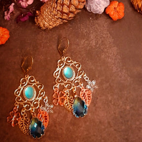 Vintage style and Victorian style statement chandelier earrings with turquoise cat eye centers, miniature garden details, layered florals, leaves, and faceted ombre glass drops by Rachel Flam Design