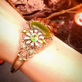 Enchanted adjustable bracelet with green cat’s-eye crystal, dimensional flowers, decorative filigree, and Swarovski sparkle, Victorian style vintage style magical fantasy jewelry