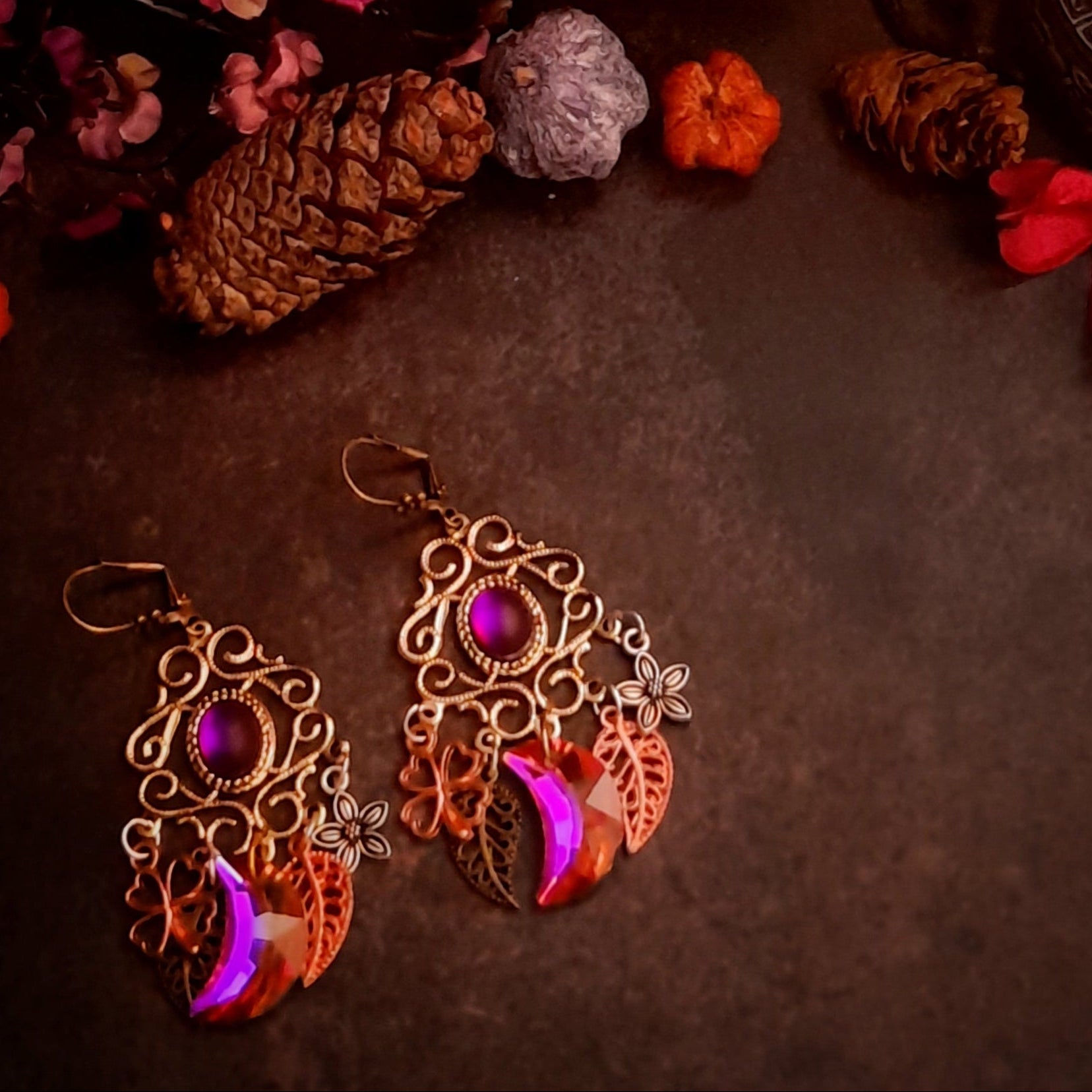 Fuchsia Swarovski chandelier earrings styled with pinecones and flowers, featuring magical nature details in Victorian style and vintage style by Rachel Flam Design