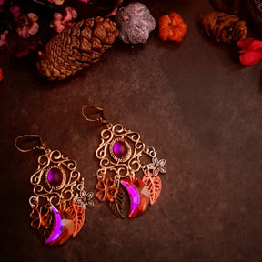 Fuchsia Swarovski chandelier earrings styled with pinecones and flowers, featuring magical nature details in Victorian style and vintage style by Rachel Flam Design