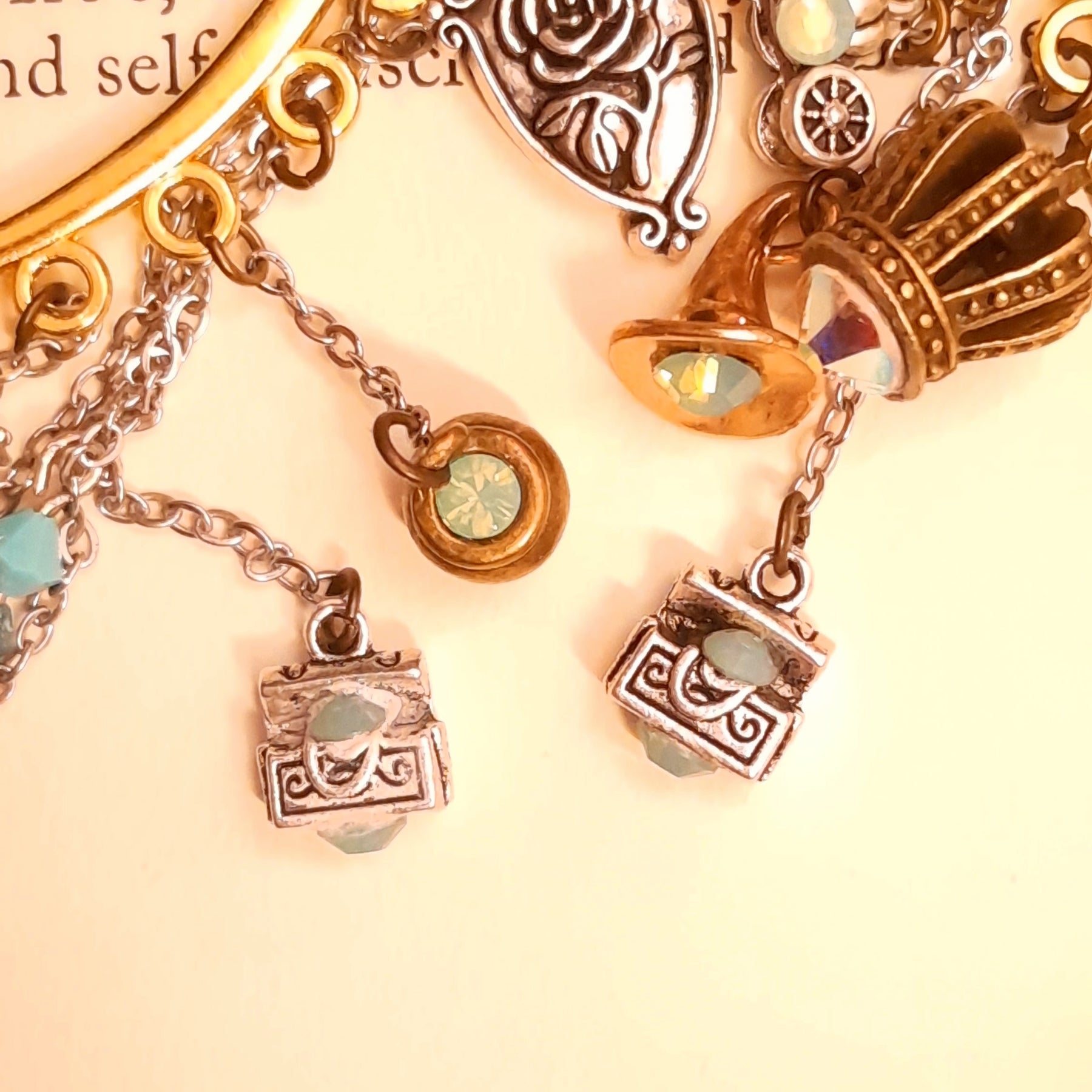 Victorian style vintage style fairy tale ear cuff for non-pierced ears with cauldron, broom, spinning wheel, genie lamp, treasure chests, family crest, oval mirror, crown, pumpkin carriage, and Once Upon a Time book charms, Pacific Opal Swarovski crystals, magical fantasy jewelry