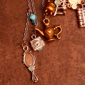Victorian style vintage style fairy tale ear wrap for non-pierced ears decorated with Once Upon a Time book, pumpkin carriage, crown, oval mirror, family crest, treasure chests, genie lamp, spinning wheel, broom, and cauldron charms, Pacific Opal Swarovski crystals, handmade fantasy jewelry