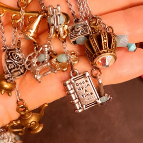 Victorian style vintage style fairy tale ear wrap for non-pierced ears featuring Once Upon a Time book, pumpkin carriage, crown, oval mirror, family crest, treasure chests, genie lamp, spinning wheel, broom, and cauldron charms with Pacific Opal Swarovski crystals, handmade fantasy jewelry