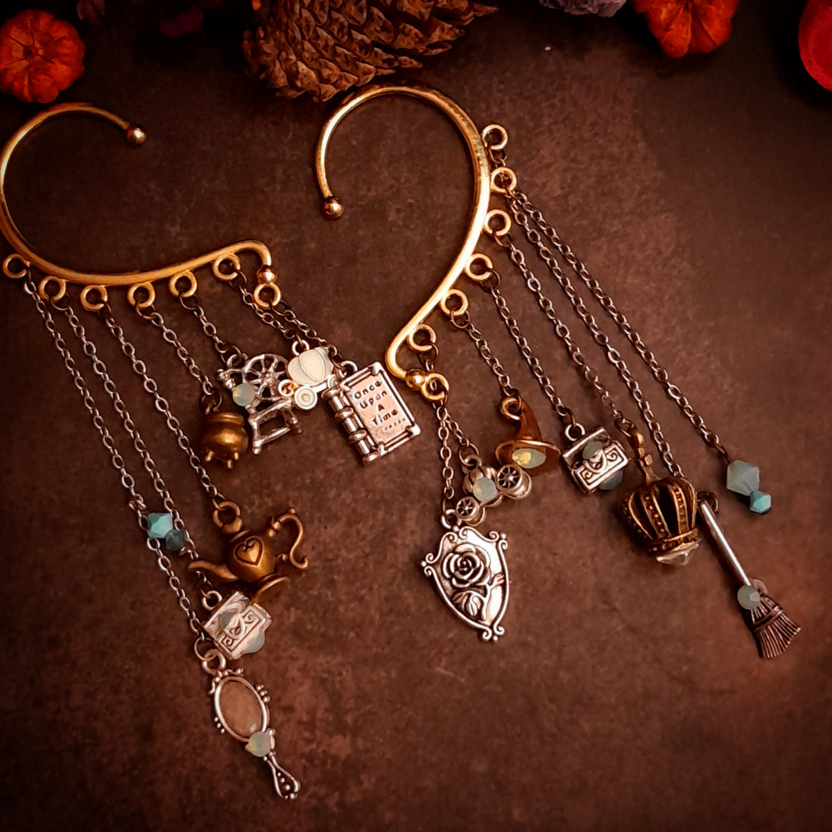 Victorian style vintage style fairy tale ear wrap for non-pierced ears with Once Upon a Time book, pumpkin carriage, crown, oval mirror, family crest, treasure chests, genie lamp, spinning wheel, broom, and cauldron charms, Pacific Opal Swarovski crystals, magical fantasy jewelry