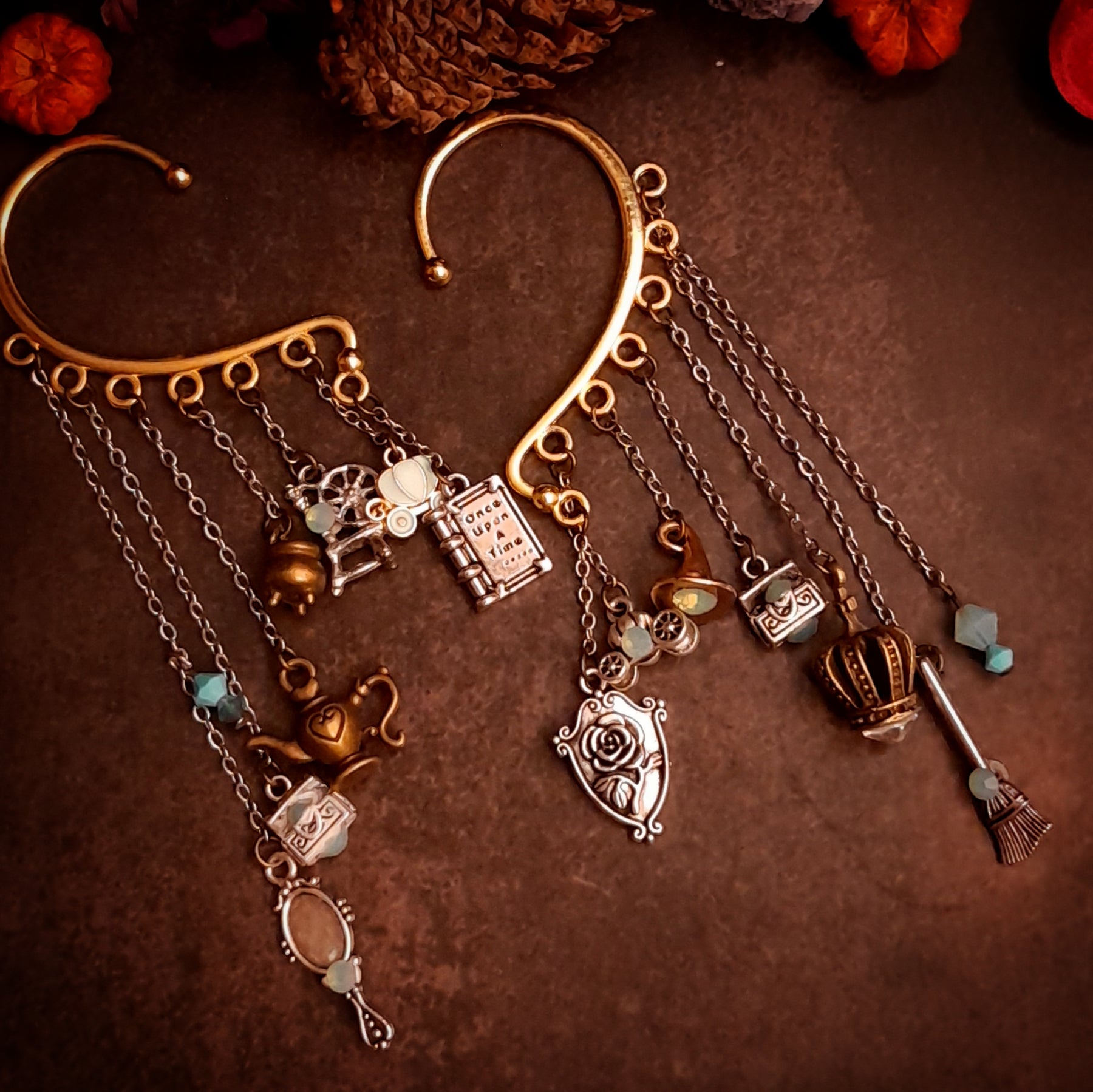 Victorian style vintage style fairy tale ear wrap for non-pierced ears with Once Upon a Time book, pumpkin carriage, crown, oval mirror, family crest, treasure chests, genie lamp, spinning wheel, broom, and cauldron charms, Pacific Opal Swarovski crystals, magical fantasy jewelry