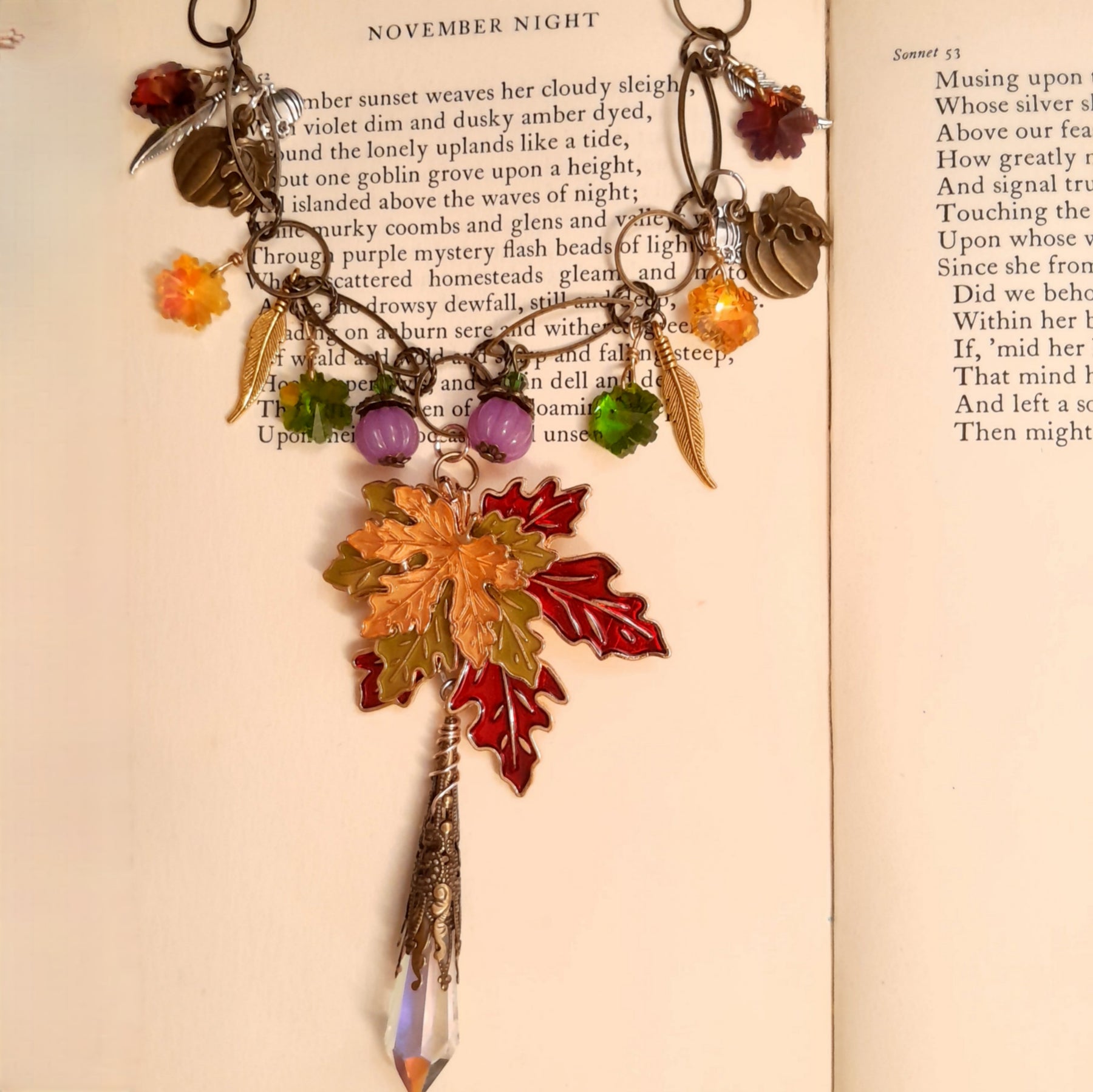 Full view of a handmade Halloween fantasy nature necklace with pumpkins, dangling leaves, feathers and Swarovski crystals in Victorian style and vintage style by Rachel Flam Design