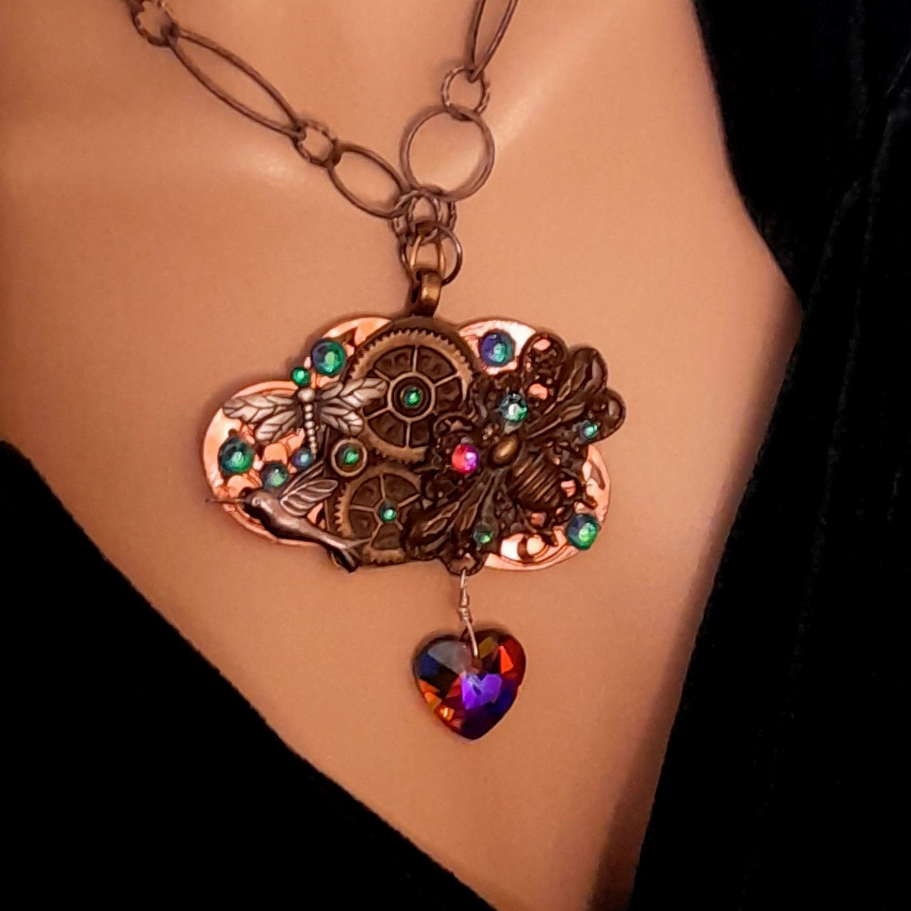 
Fantasy steampunk necklace handmade with bee, hummingbird, dragonfly, watch gears, and world-renowned genuine Swarovski crystals in multicolored heart

