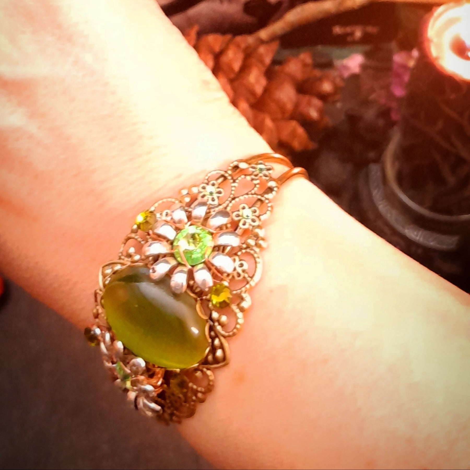 Green flower bracelet featuring a luminous cat’s-eye centerpiece, ornate details, and sparkling Swarovski crystals, Victorian style vintage style handmade fantasy jewelry