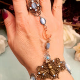 Handmade magical fantasy bee hand chain  slave bracelet on hand close up of adjustable filigree ring with blue cat's eye crystal and Swarovski crystals Victorian style vintage style