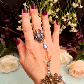 Handmade magical fantasy bee hand chain  slave bracelet on hand close up of adjustable filigree ring with blue cat's eye crystal and Swarovski crystals Victorian style vintage style