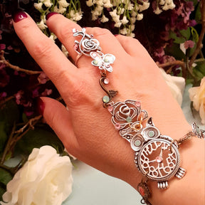 Magical fantasy owl hand chain worn on hand full view showing rose ring butterfly swirl rose charm and owl with Swarovski crystals Victorian style vintage style