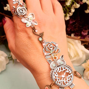 Handmade magical fantasy owl hand chain worn on hand top down view showing full piece from floral rose ring to owl centerpiece with Swarovski crystals Victorian style vintage style