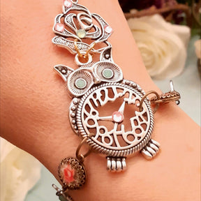 Handmade fantasy owl hand chain worn on wrist close up of owl centerpiece and open rose charm with mint and pink Swarovski crystals Victorian style vintage style