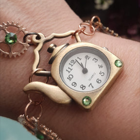 Magical fantasy hand chain teapot watch Alice in Wonderland with green Swarovski crystals flat lay angled view, Victorian style vintage style