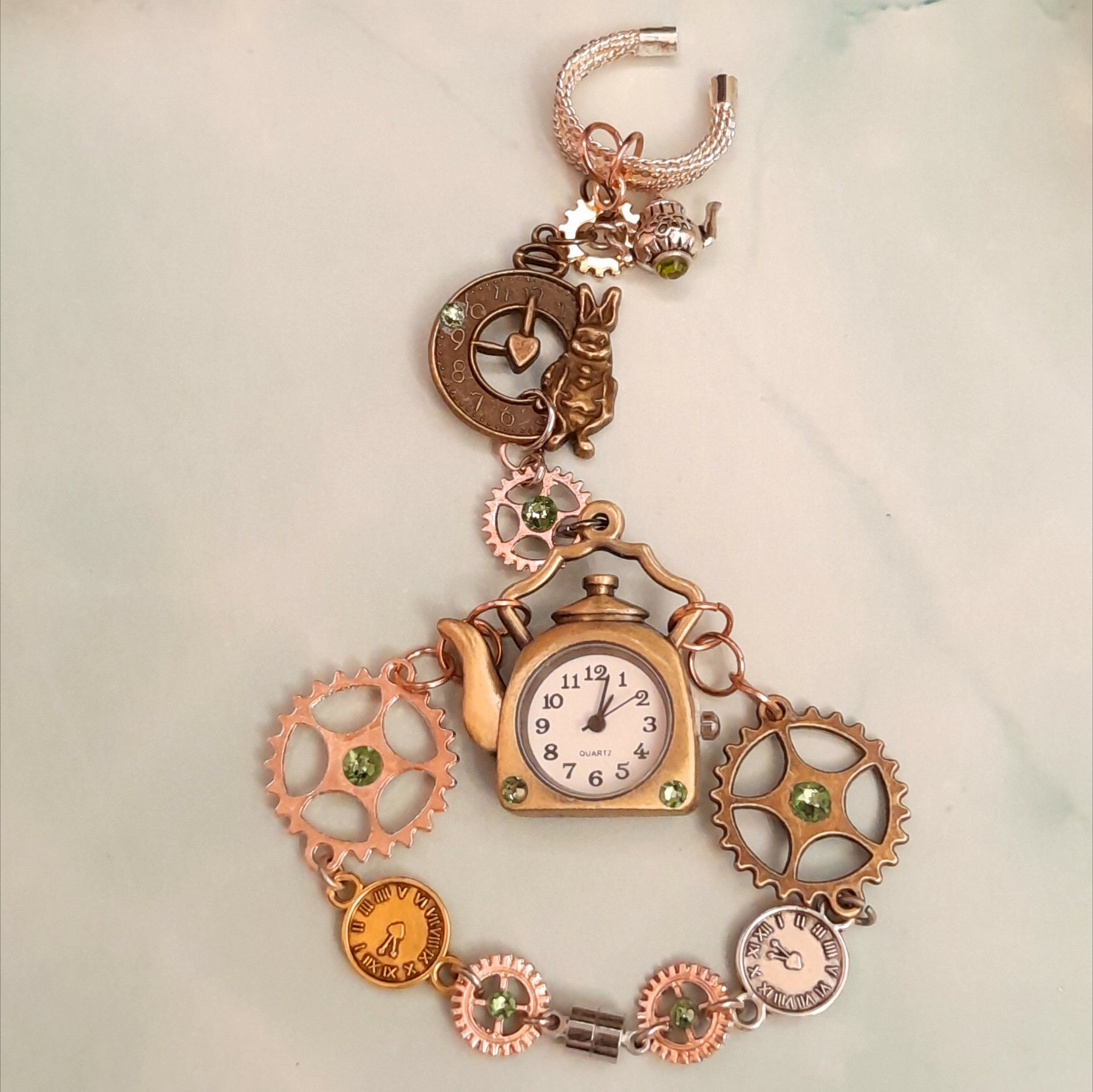 Magical fantasy hand chain teapot watch Alice in Wonderland with green Swarovski crystals flat lay front view, Victorian style vintage style