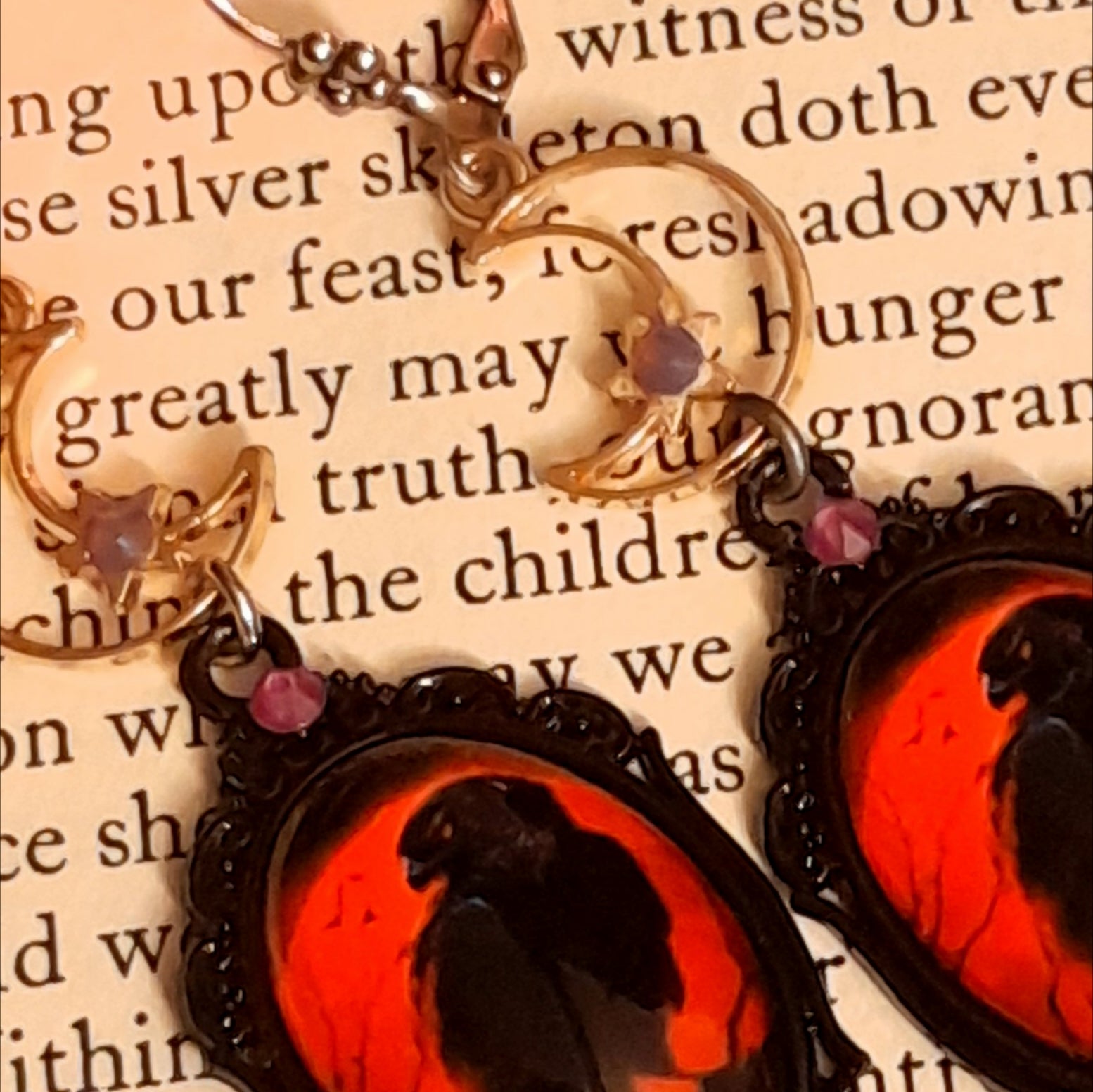 Handmade magical crow earrings with moonlit crescent scenes, smoky purple Swarovski crystals, red cabochons, purple pumpkins, and autumn nature details, Victorian style and vintage style fantasy jewelry by Rachel Flam Design
