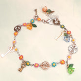 Handmade rainbow steampunk charm anklet with vintage keys, gear charms, multicolor enamel daisy flowers, and crystal flower beads worn on ankle, Victorian style vintage style fantasy jewelry