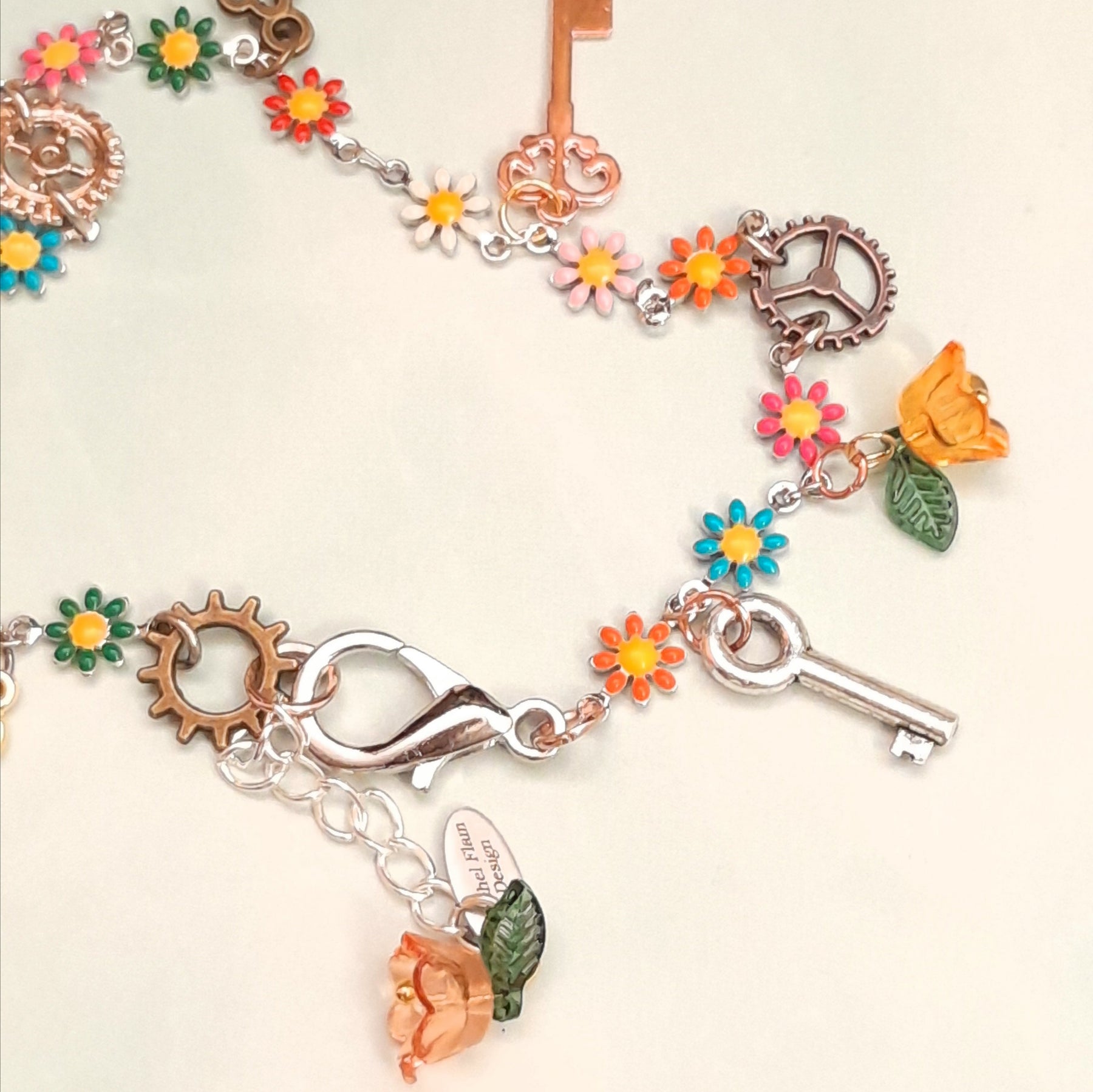 Handmade steampunk charm anklet with vintage key, gear charm, multicolor enamel daisy flowers, orange crystal flower bead, and leaf charm, Victorian style vintage style